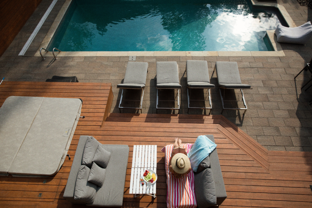 View From Above Of Pool With Lounge Chairs Woman Sunbathing Outdoor Couch With Pillows Table How To Design An Amazing Outdoor Space