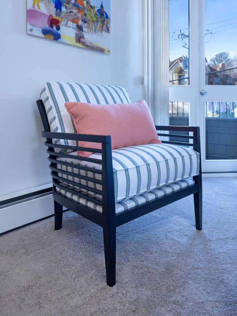Santa Cruz Condo Bedroom With Striped Accent Chair And Coral Pillow Near Window With Natural Light