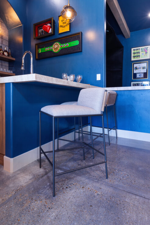 morada-ktj-design-co-gameroom-four-hands-counter-stool-polished-concrete-floors-navy-blue-walls-boxing-sports-bar_ho9a1448