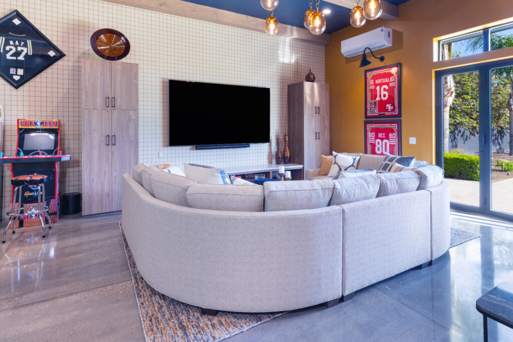 Morada Ktj Design Co Gameroom Large Sectional 49ers Plaid Wallpaper Gold Walls Brass Chandelier Polished Concrete Folding Door Ho9a1374