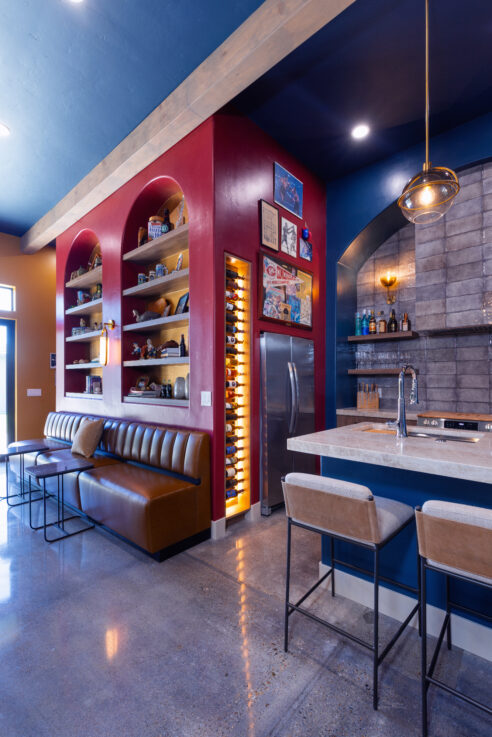 morada-ktj-design-co-gameroom-sports-bar-kitchen-polished-concrete-floors-dark-blue-ceiling-49er-red-arched-built-in-bookcase-gold_ho9a1439