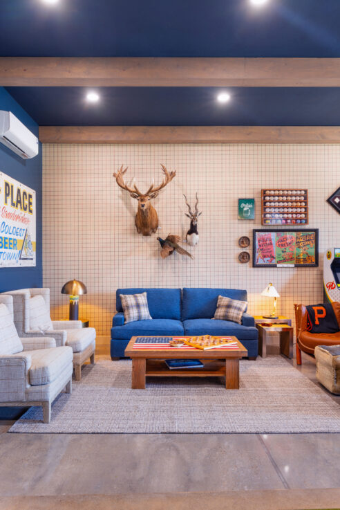 morada-ktj-design-co-gameroom-stag-head-buck-head-navy-sofa-bed-polished-concrete-floors-plaid-wallpaper-wood-beams_ho9a1315