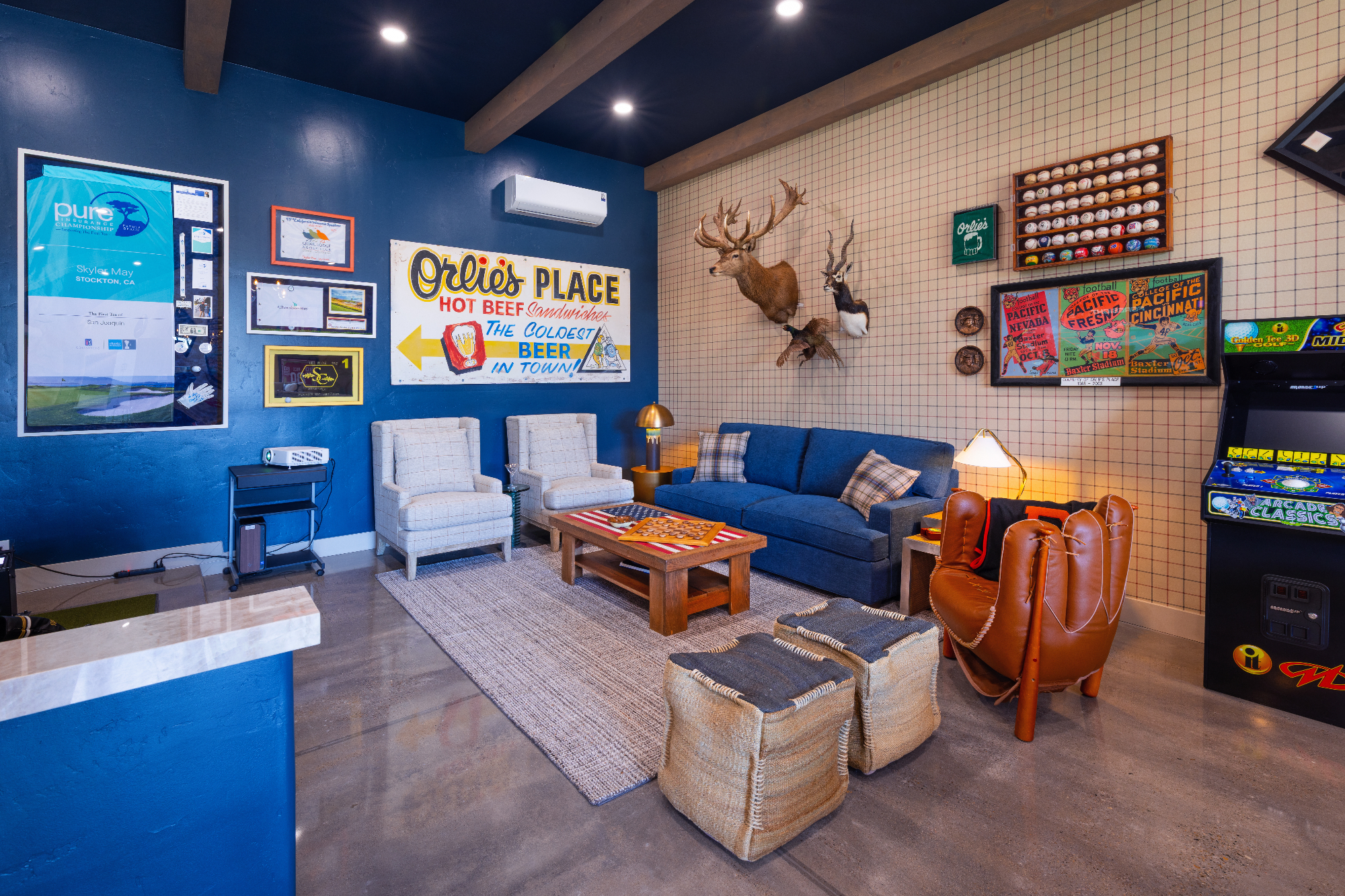 morada-ktj-design-co-navy-ceiling-wall-plaid-wallpaper-buck-stag-heads-navy-sofa-bed-baseball-chair-arcade-games-poufs-polished-concrete_ho9a1305
