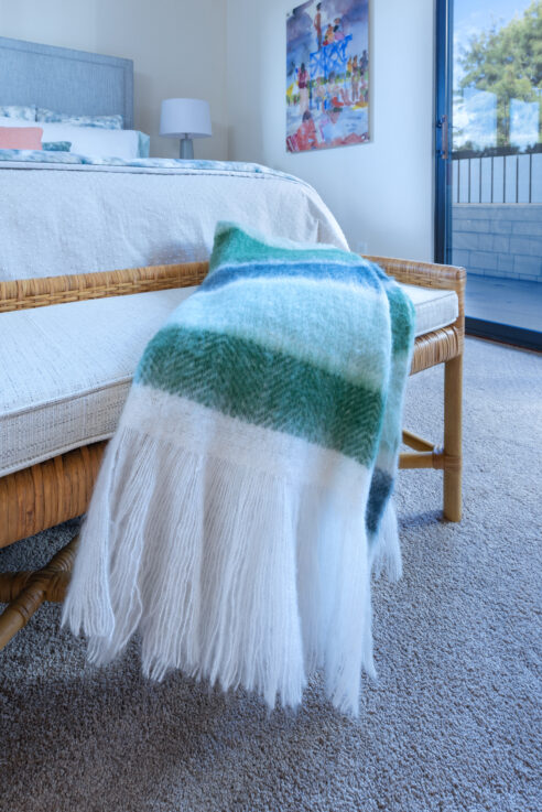 ktj-design-co-santa-cruz-beach-condo-bedroom-wicker-bench-blue-green-throw-blanket_ho9a6380
