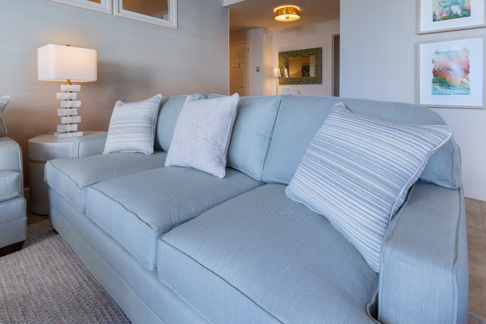 ktj-design-co-santa-cruz-beach-condo-living-room-blue-green-sofa-striped-throw-pillows-marble-lamp-grass-cloth-wallpaper_ho9a6497